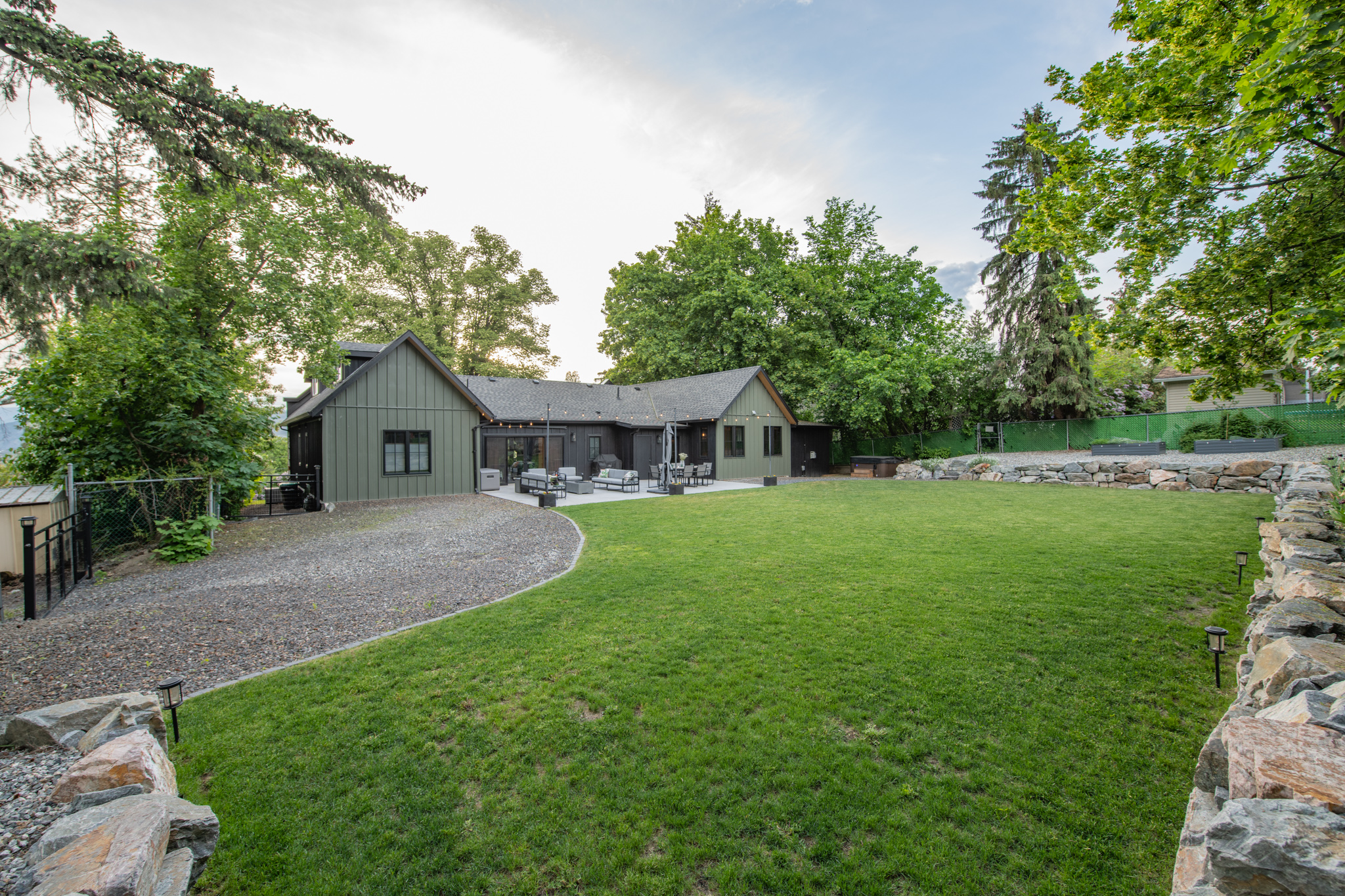 Wide lawn bordered by stone walls and mature trees