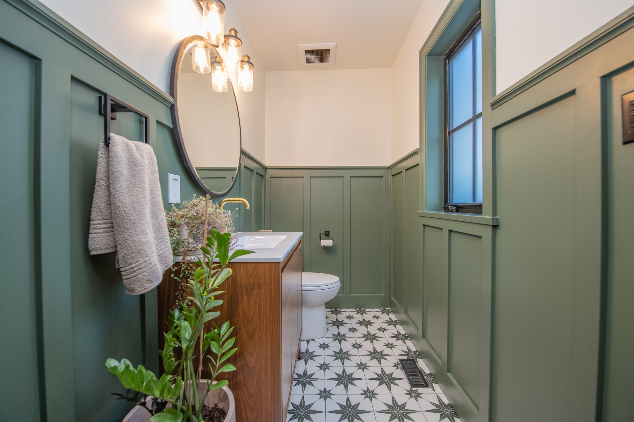 Bathroom with patterned tile and green paneling