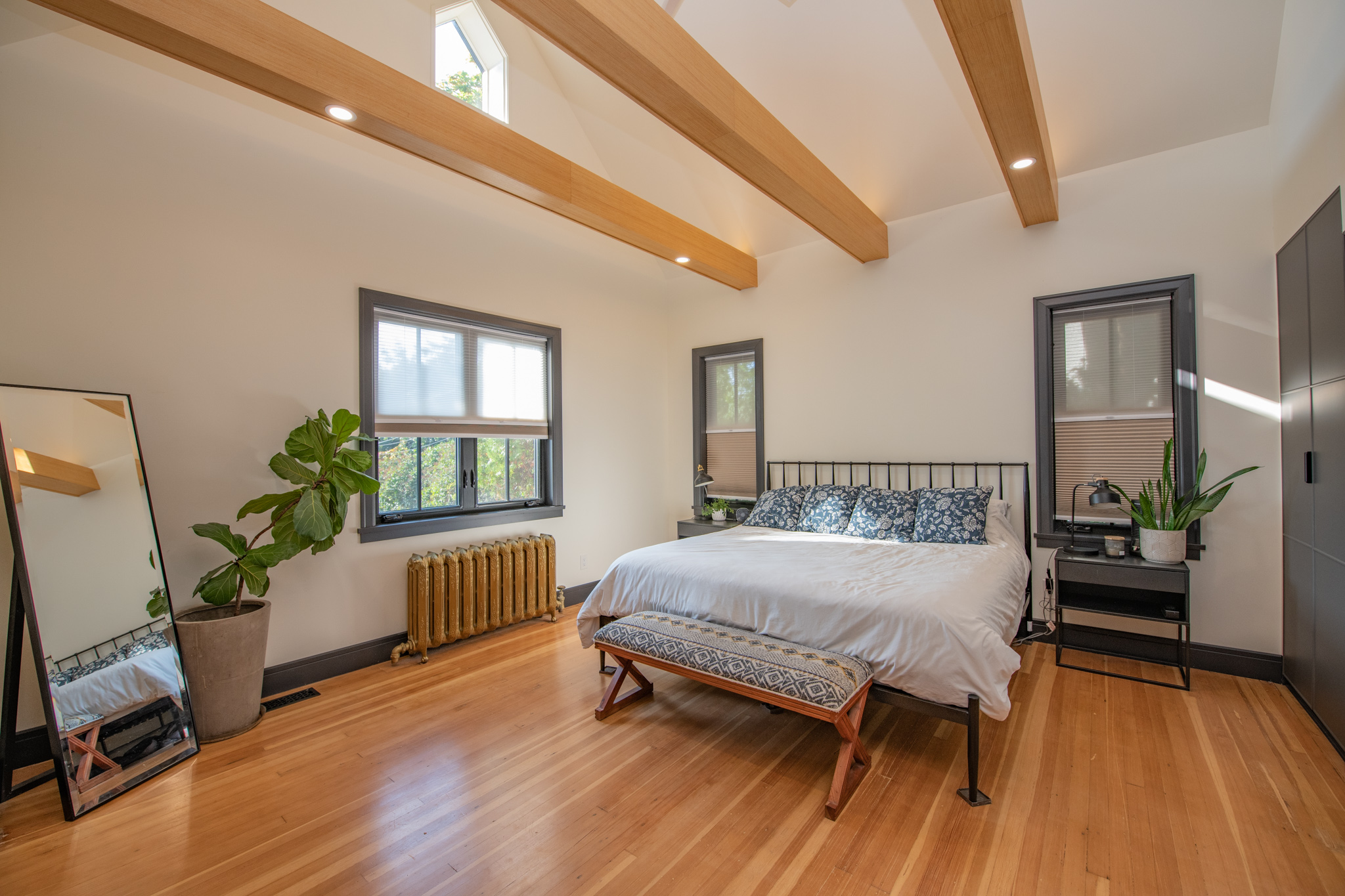 Primary bedroom with exposed beams and hardwood floors